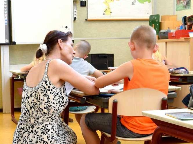 Woman is helping younger child with school work