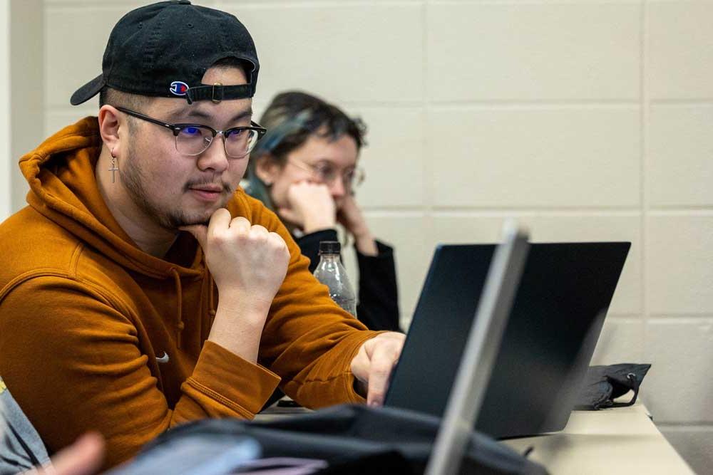 年轻的男大学生在笔记本电脑上学习