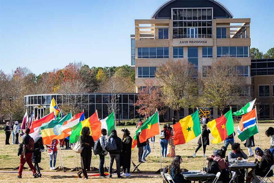 students holding global flags on the campuse green